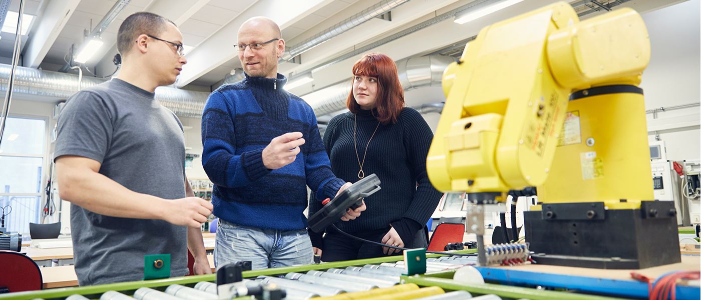 Underviser fra automatik- og proces viser studerende maskine
